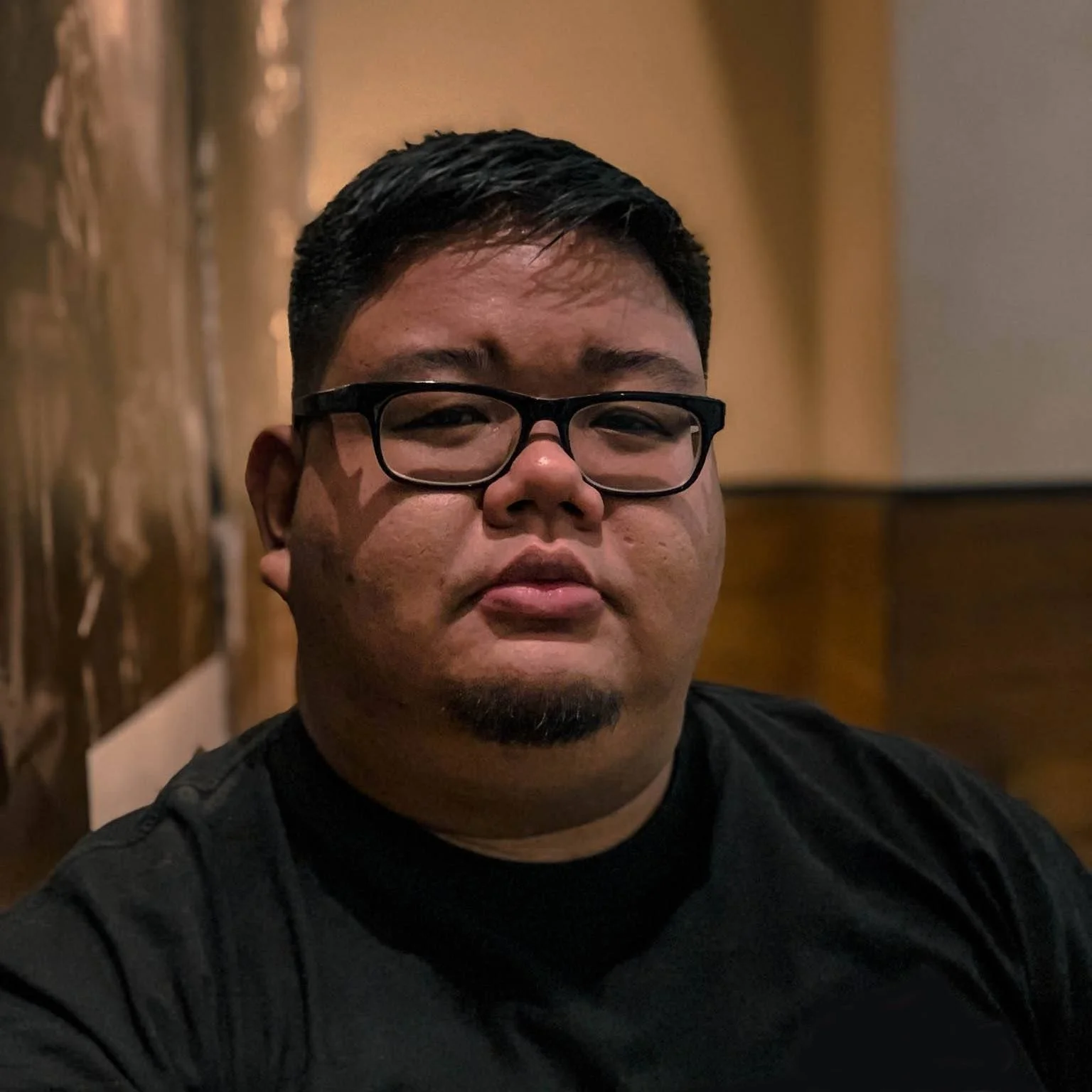 Nikko Trinidad wearing a black shirt on a cafe