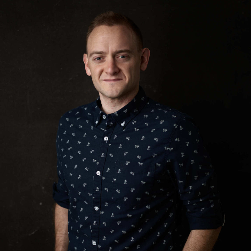 Tim Courtney of Roundabout posing in a dark blue polo