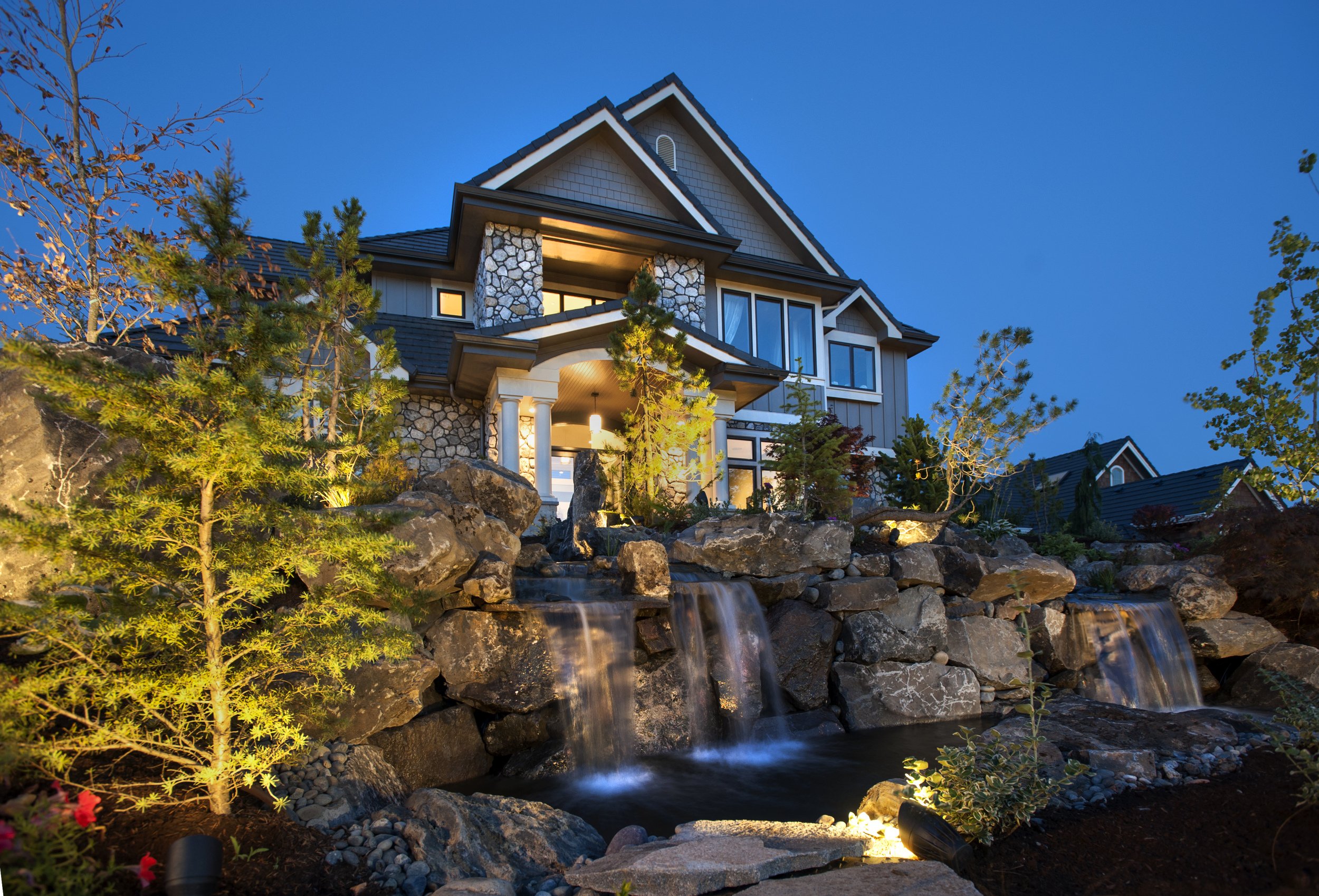 Stunning outdoor lighting in front porch and pond.