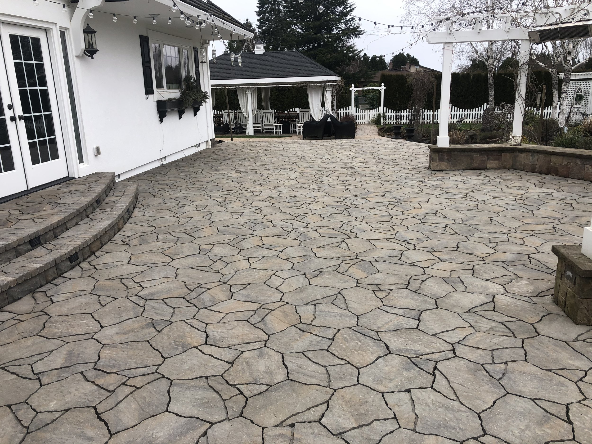Stone paver patio with stone wall.