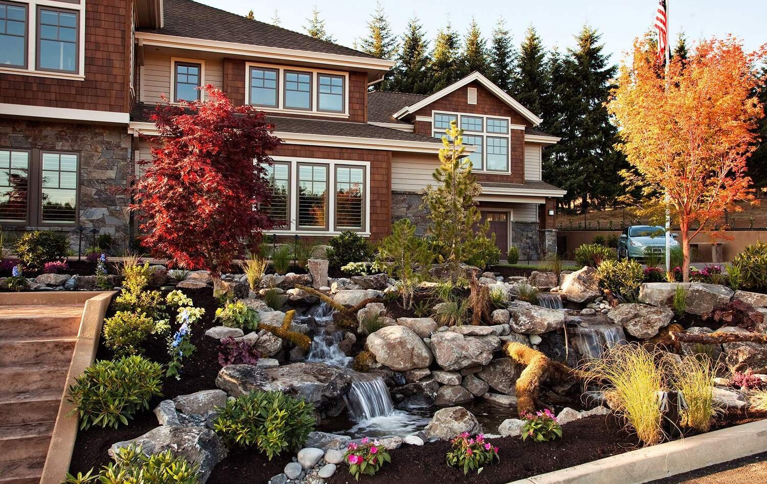 A beautiful home with a cascading waterfall and lush landscaping in the backyard.