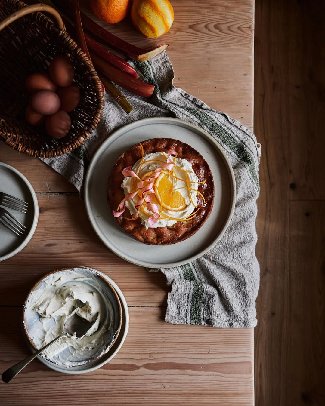 flatlay image of cake with mascarpone, orange and rhubarb curl garnish
