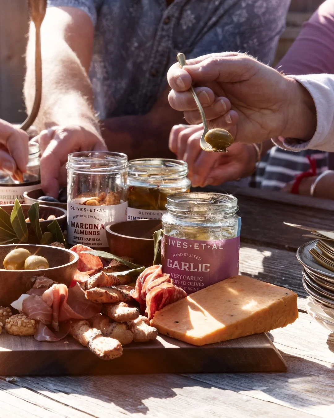 There is something quietly beautiful about gathering around a sharing board in the sunshine. Tearing warm bread with your hands, passing plates back and forth, glasses clinking softly as the evening stretches on a little longer than planned.

In a wo