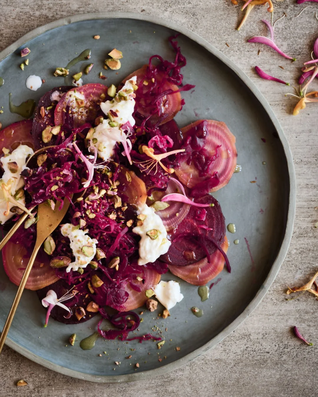 overhead macro image of beet salad with burrata and pistachio texture in bright scene