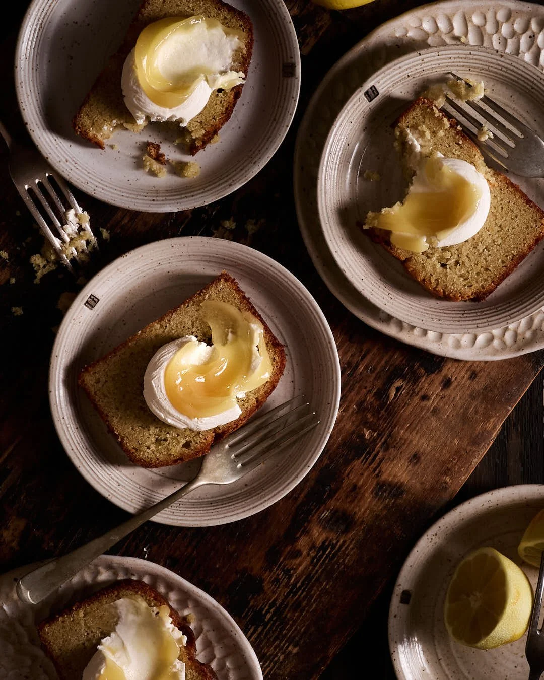 flatlay image of slices of lemon loaf garnished with mascarpone and lemon curd in rustic wood moody scene