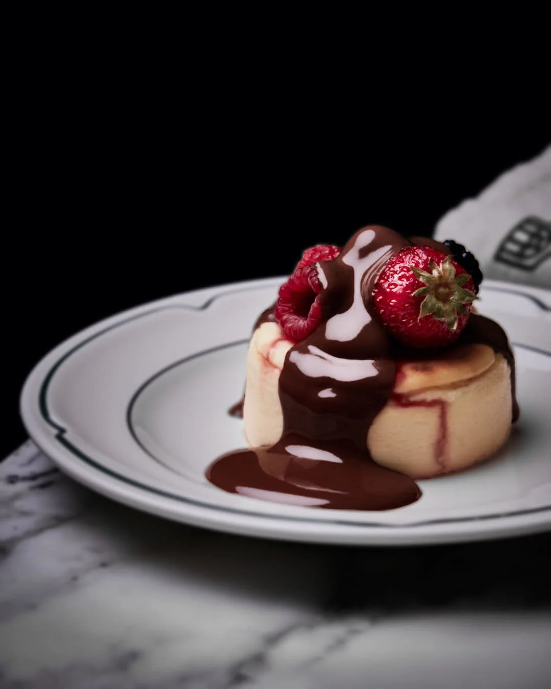 cheesecake with stunning strawberry top with unctuous chocolate glaze drizzle