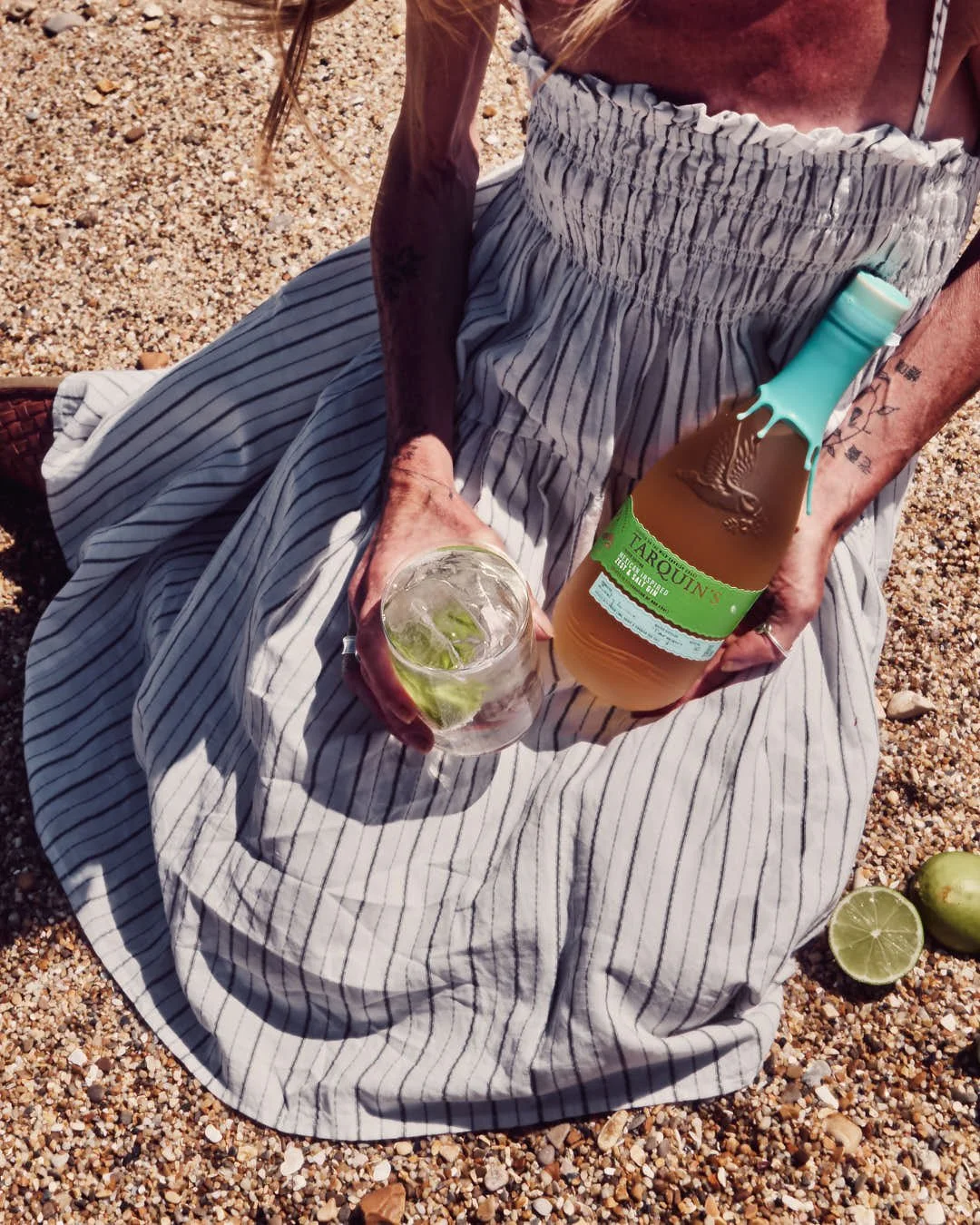 tarquins gin in girls hand with glass and dress