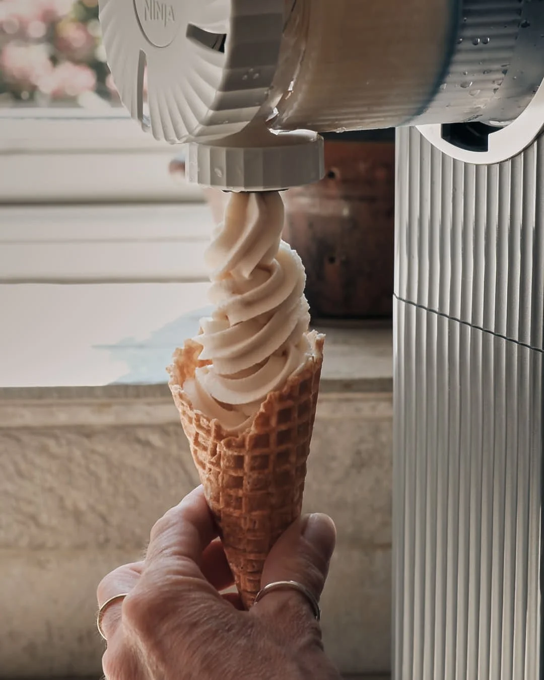 ice cream being dispensed from mr whippy machine with hand