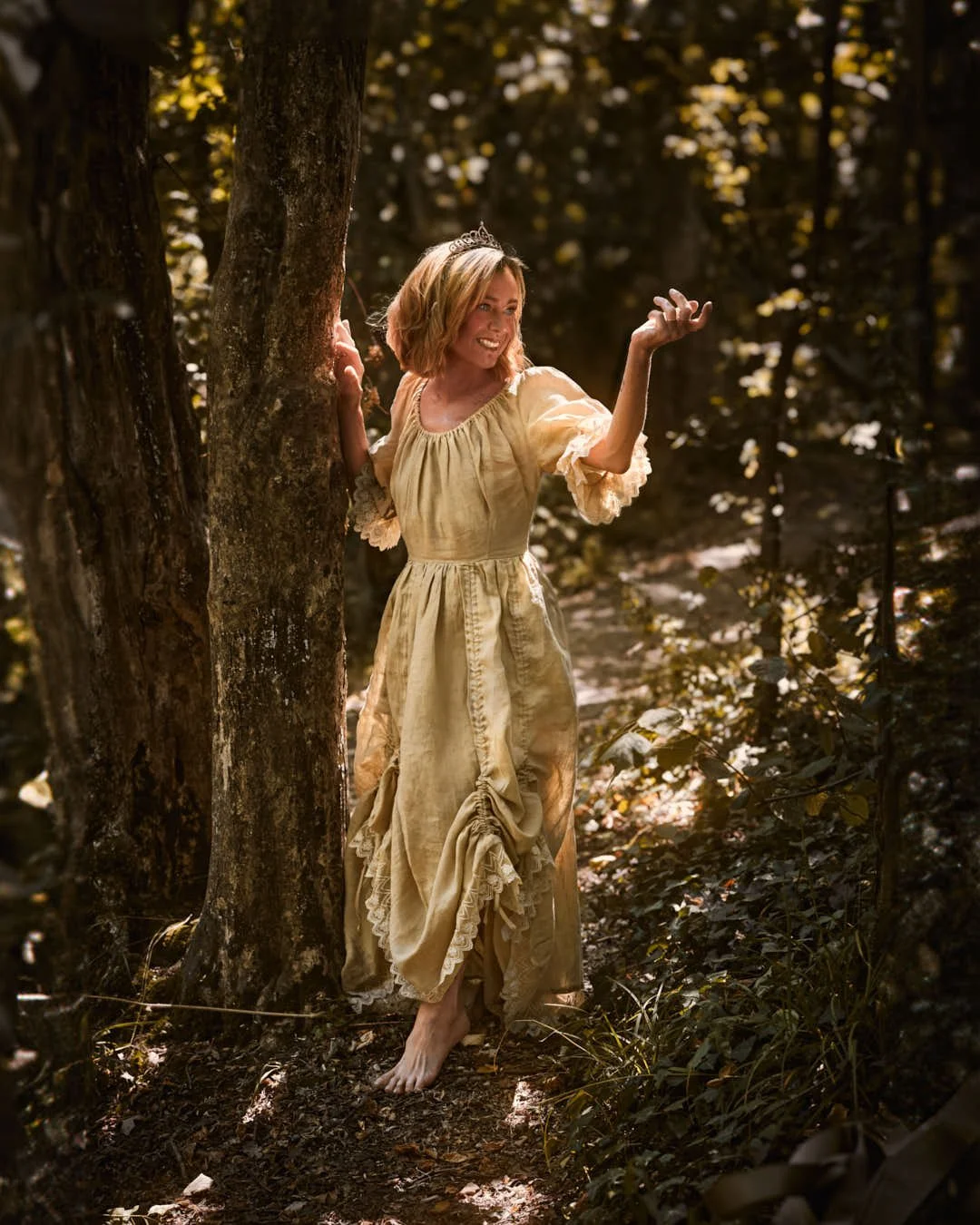girl by tree in woodland in stunning fairytale dress
