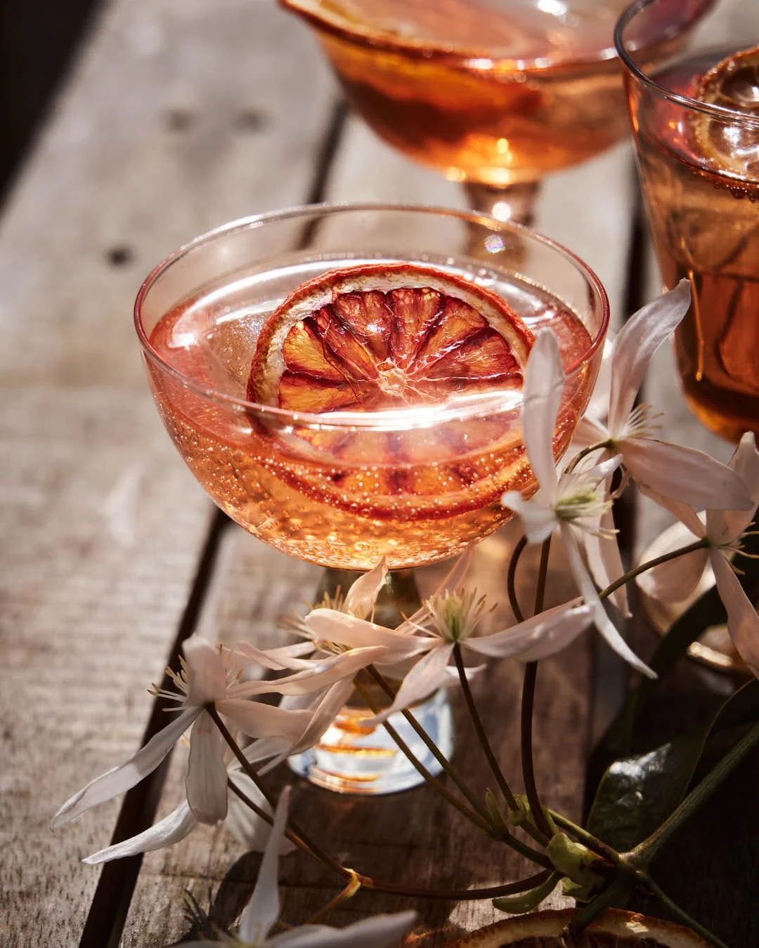 angled image of spirtz with oramge hue in glass with sunny al fresco vibes