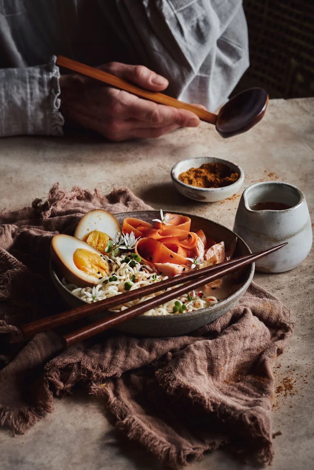 angled image of ramen noodles with eggs in rustic scene