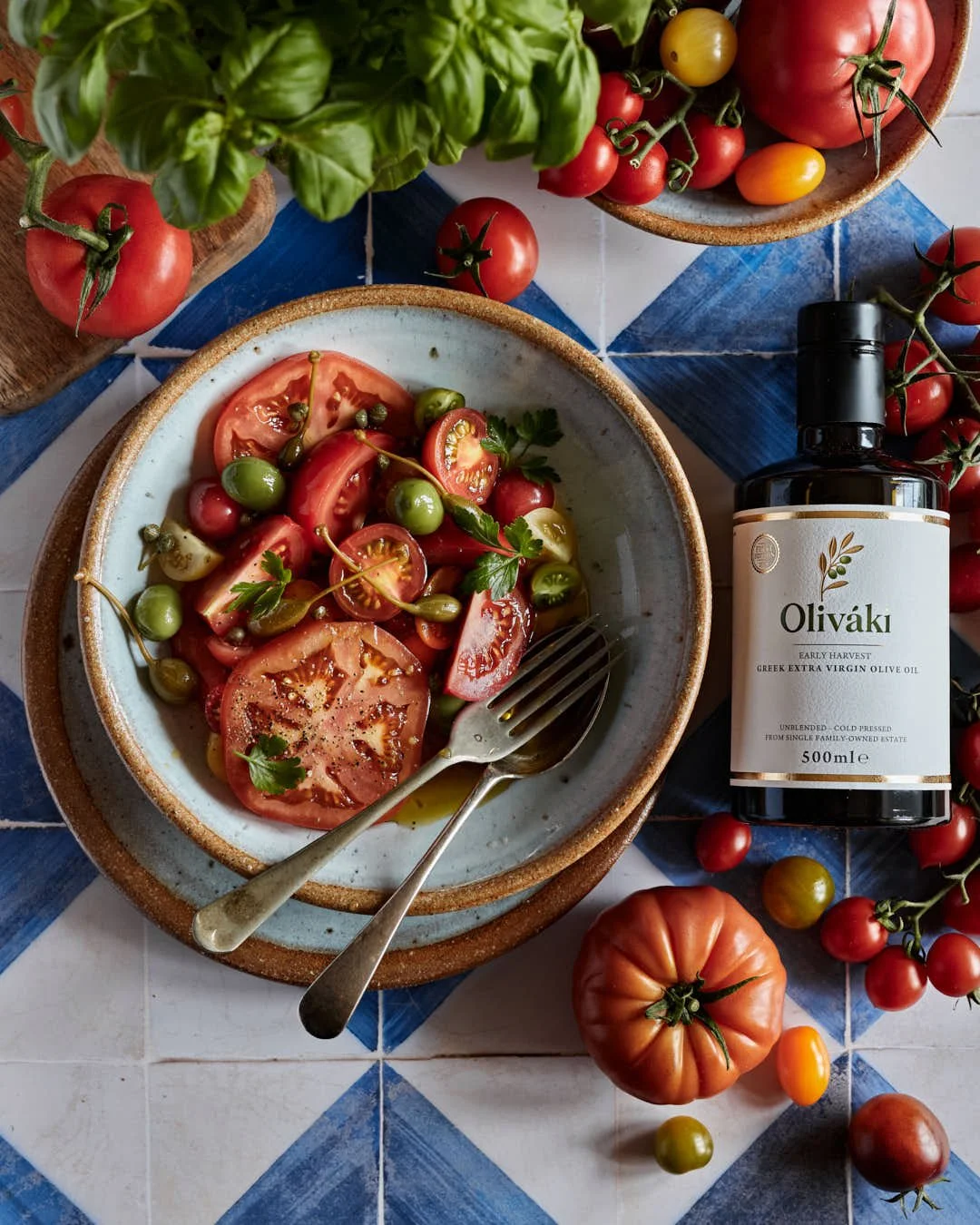 flatlay image of tomato salad on stunning blue tiled backdrop