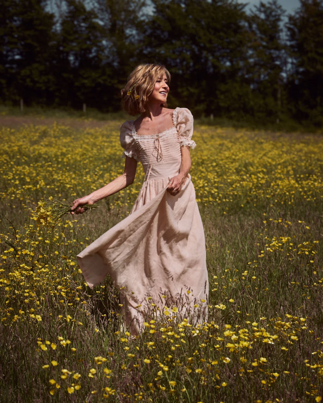 girl standing in field of wildflowers in sunlit summer scene, faerie vibes
