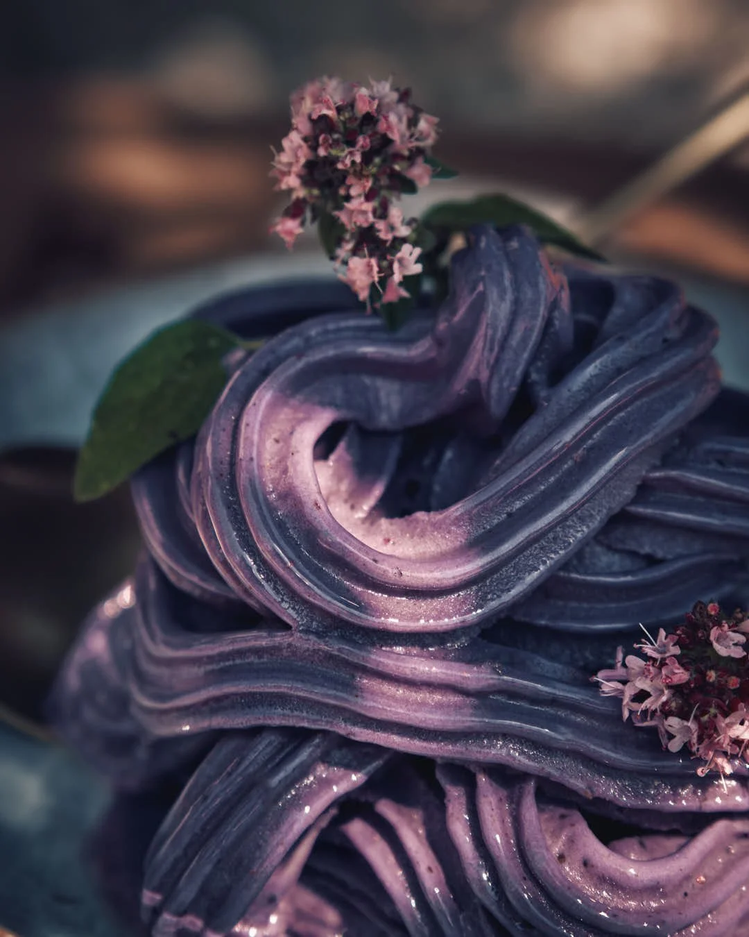 macro image of purple swirled soft serve in dappled light with marjoram flowers