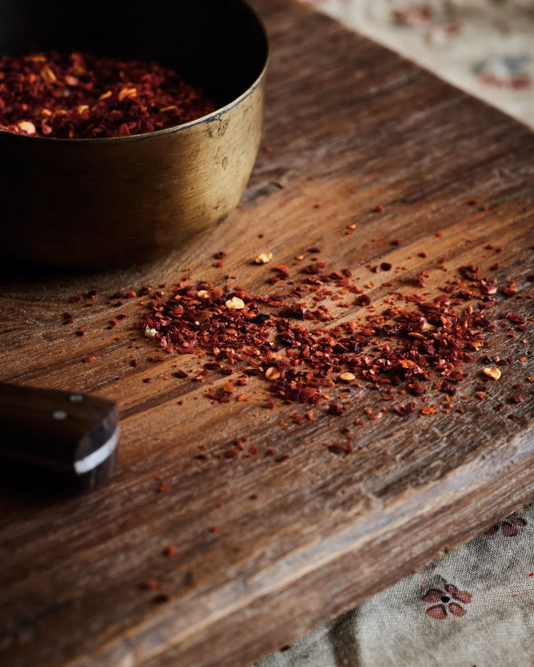 macro image of chilli flakes on chopping board in moody scene