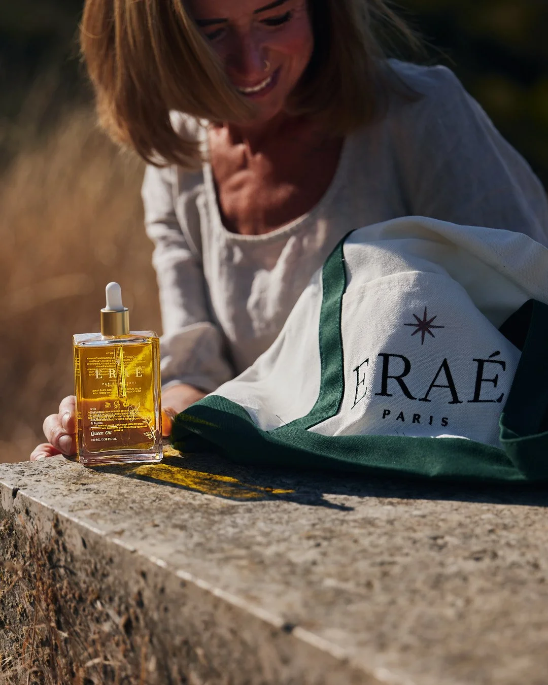 dry oil on stone with girl in beautiful sunshine to back with white and green bag