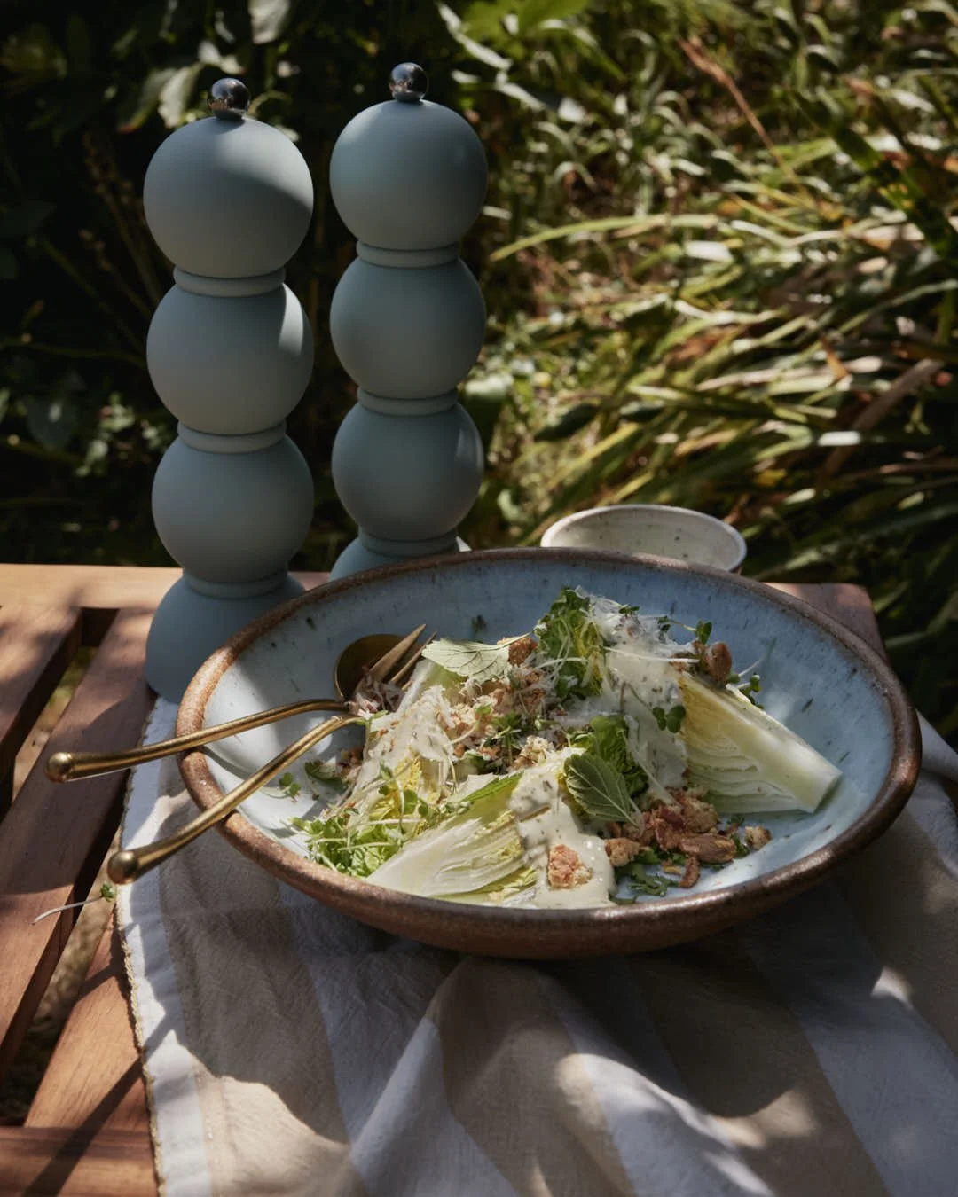 angled image of wedge lettuce salad with stunning textures and creamy dressing in summer garden scene