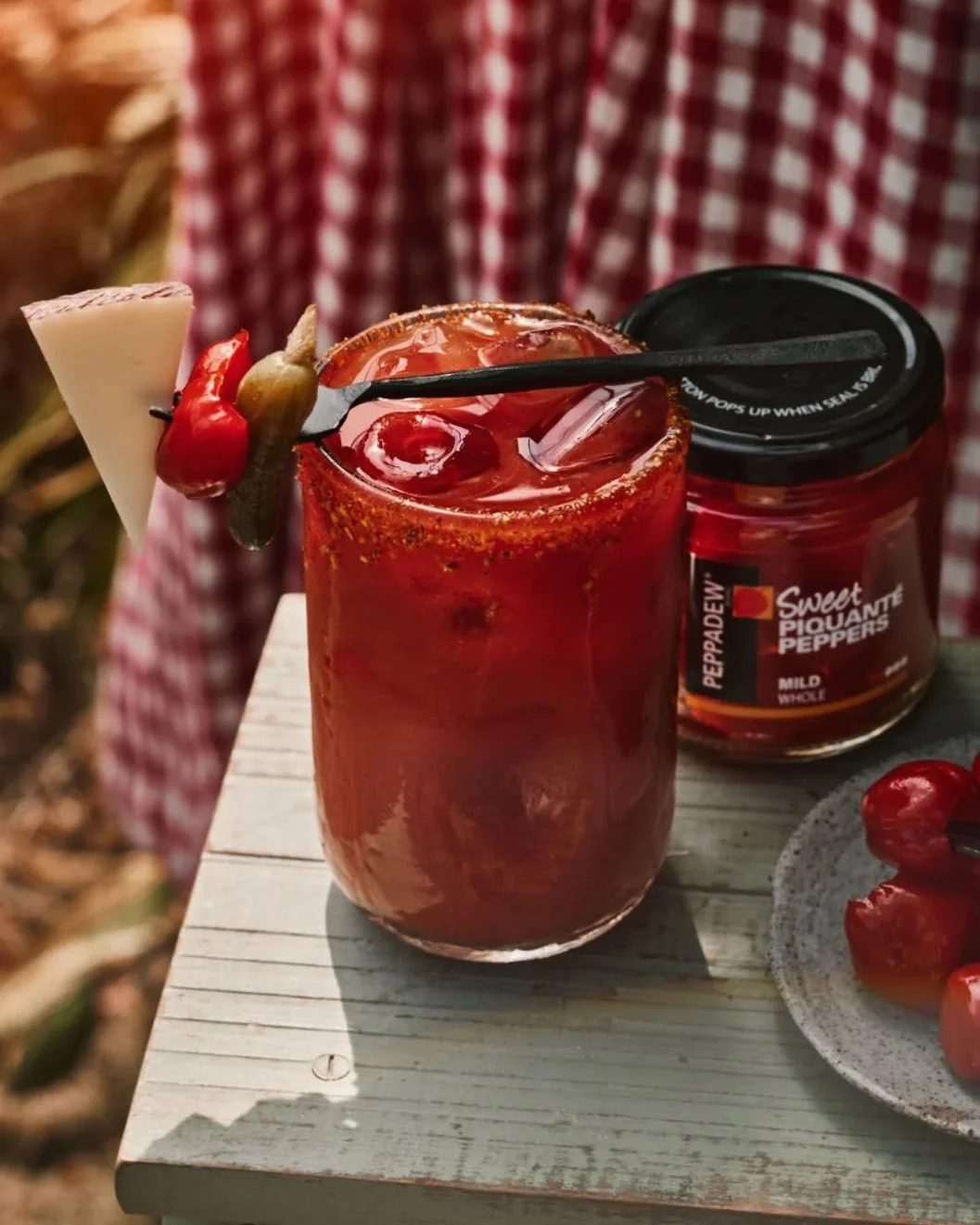 glass of tomato drink in summer scene with stunning ice and manchego wedge garnish