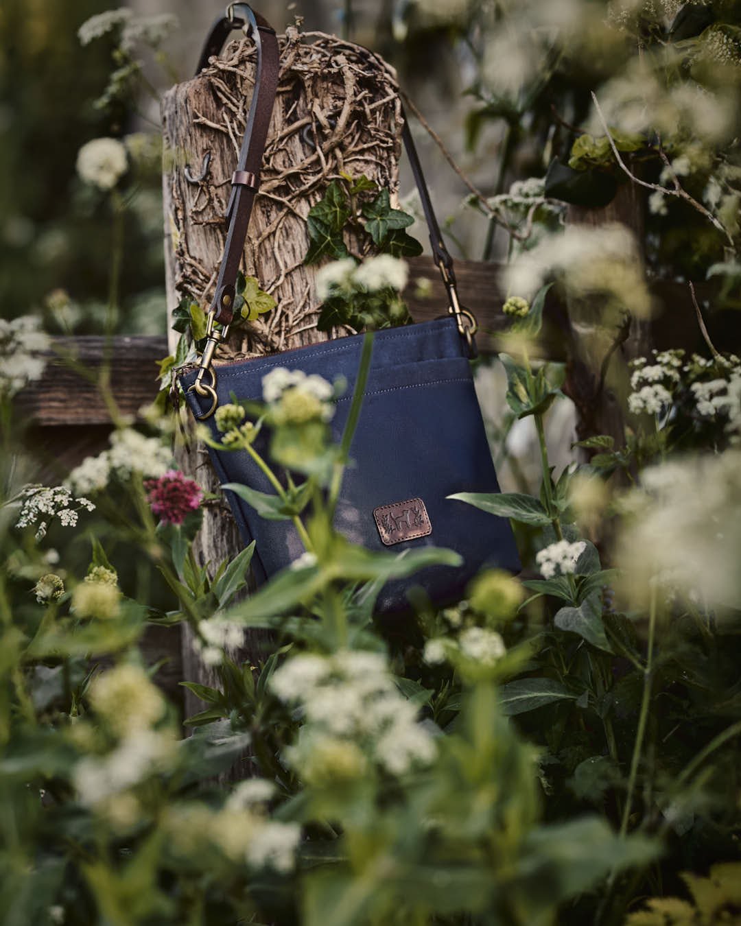 image of blue bag hanging on post with creeper and wild flowers in vintage set up
