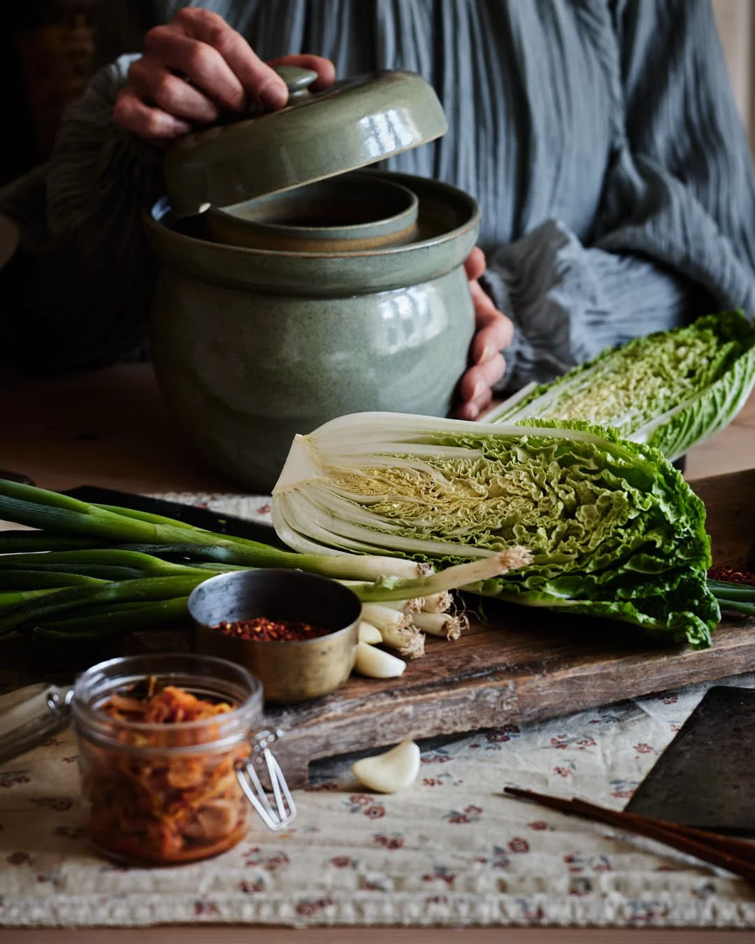girl opening fermentation crock with kimchi ingredients