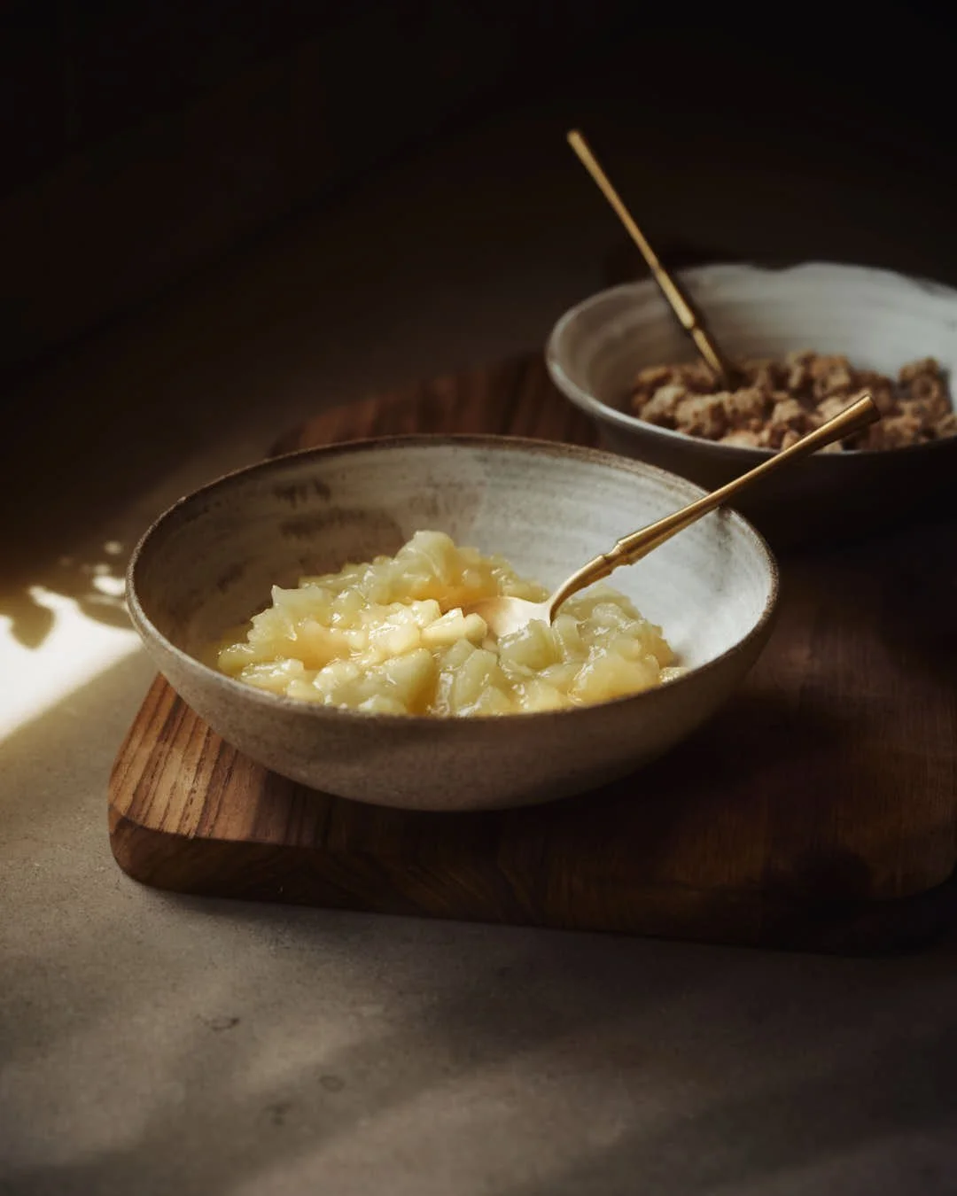 bowls of apple compote and streusel on wooden board