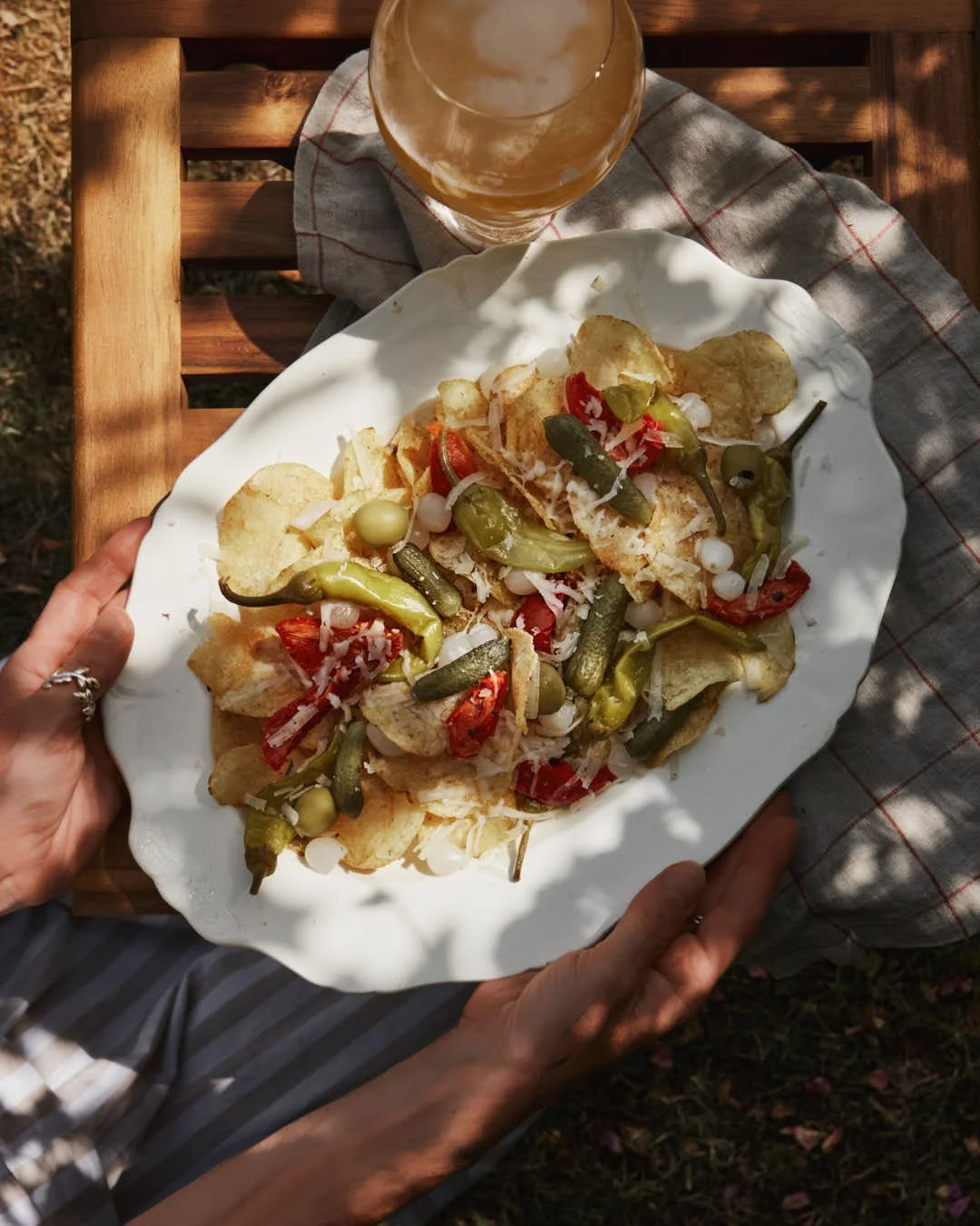 flatlay image of cream vintage platter with crisps topped with array of charcuterie with pickles and cheese