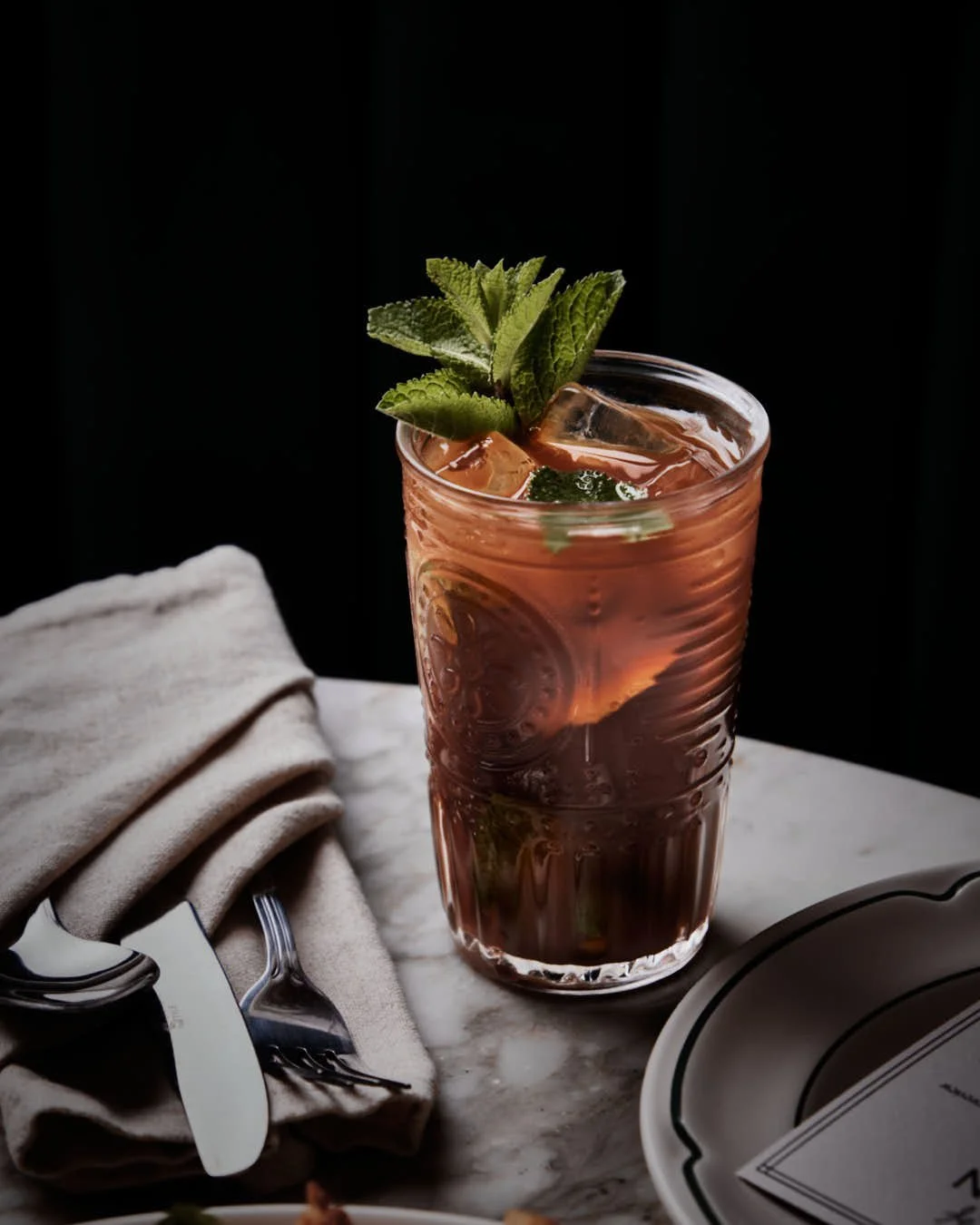 restaurant table scene with with focus on cocktail to centre