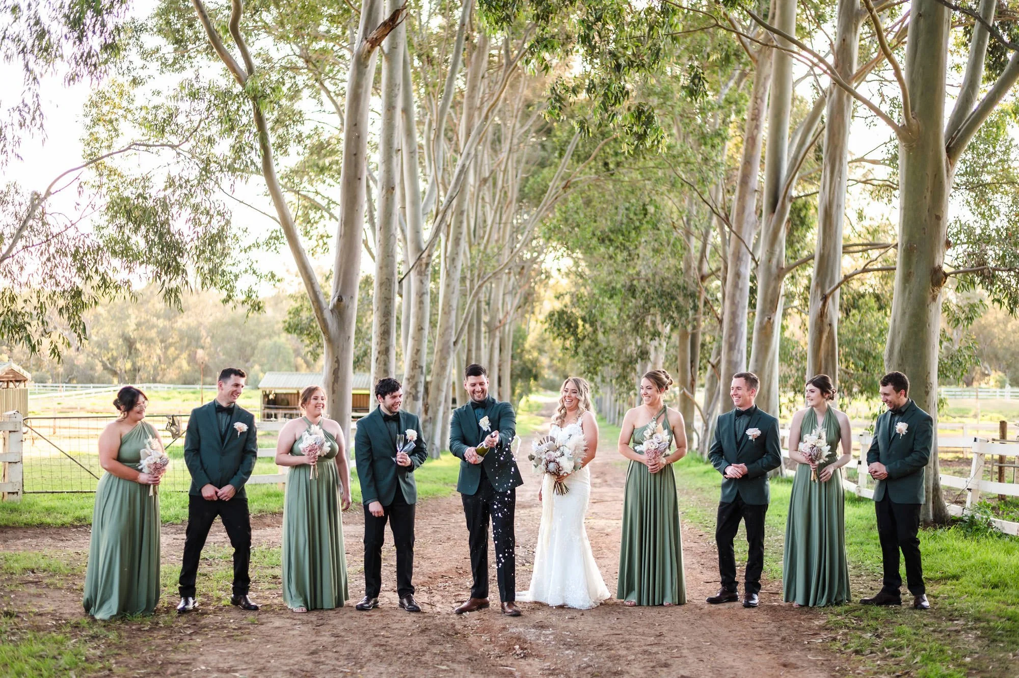 Bridal party champagne pop in the tree lined laneway at Brookleigh Estate in the Swan Valley.