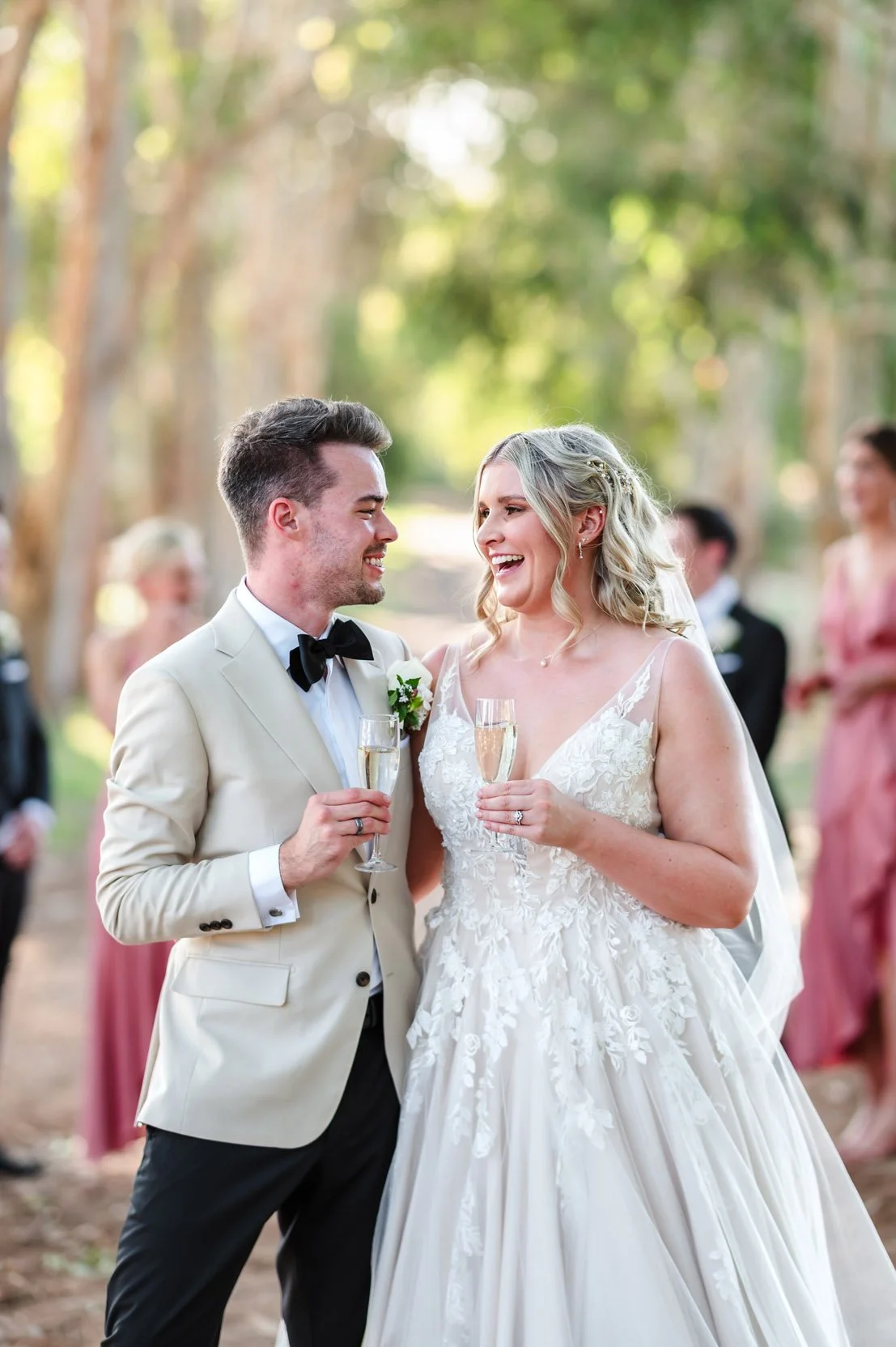 Wedding couple celebrating with champagne in the tree lined laneway at Brookleigh Estate, Swan Valley.