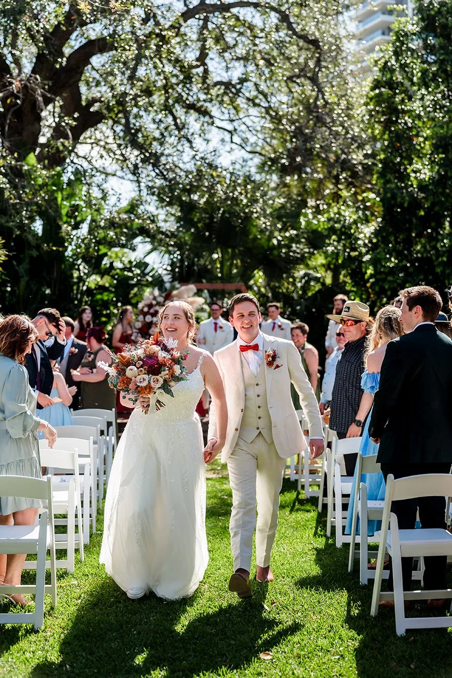 Joyful moment of a couple coming back down the ailse after getting married at the Perth Zoo.
