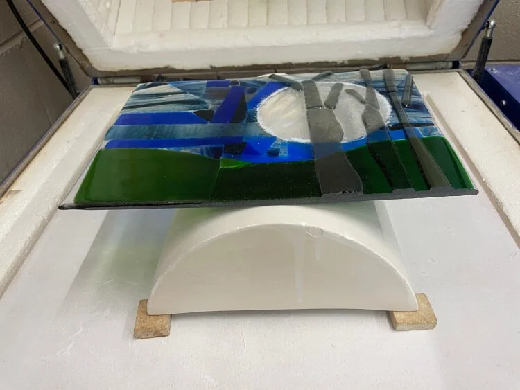 The winter scene has been fired and is balanced on top of a slip cast mould ready to be slumped.