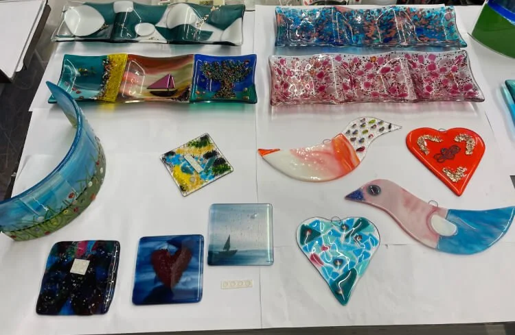 Glass dishes, hearts, birds are laid out on the table, ready for the excited makers to collect their work.