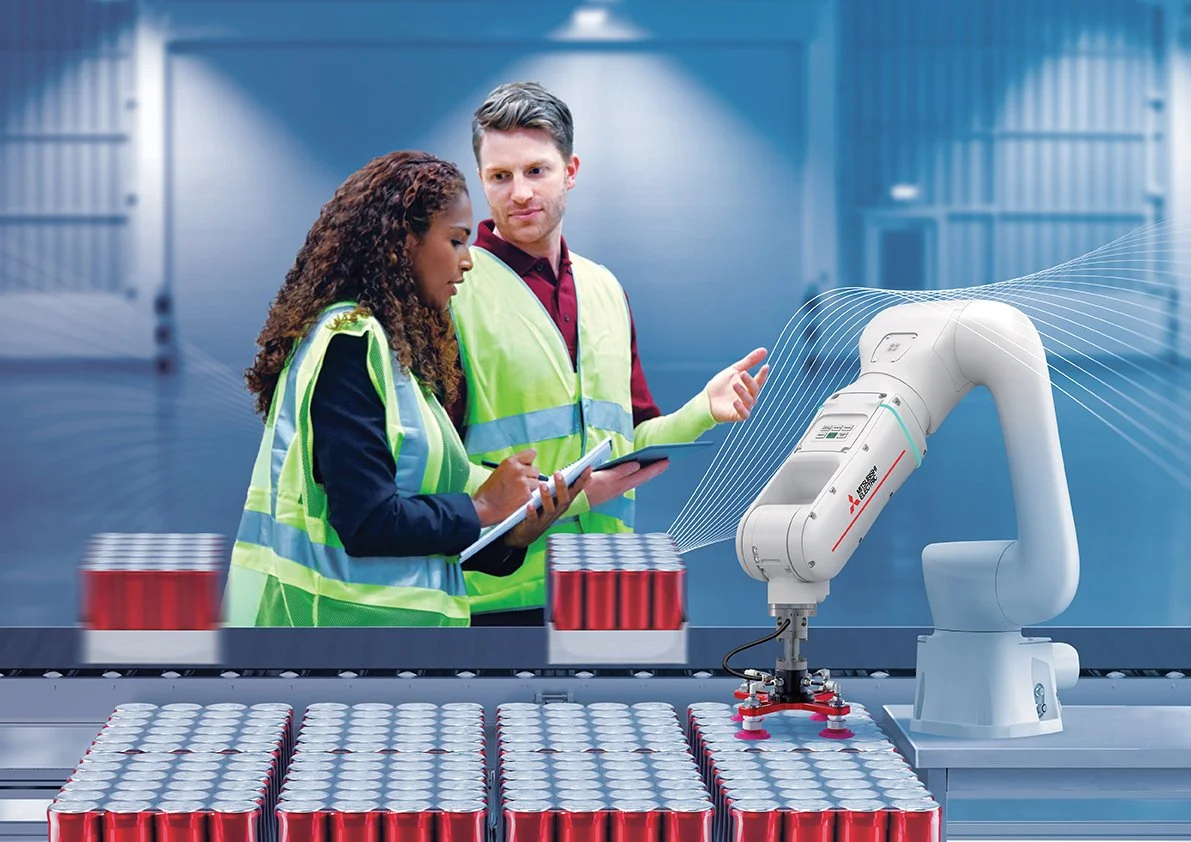 Two factory workers in safety vests operating robotic machinery to handle cans on a production line.