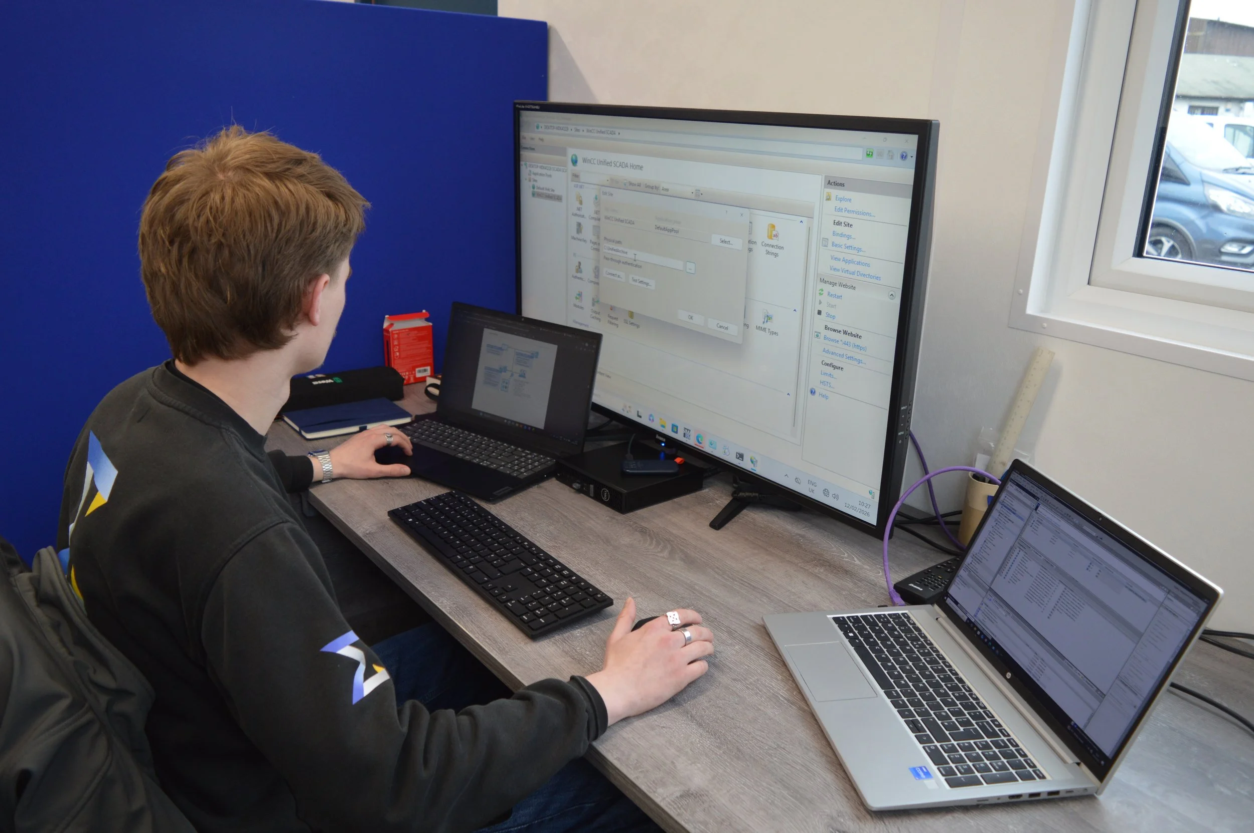 Shows software engineer at screens programming