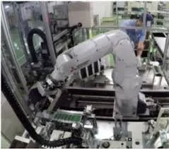Industrial robotic arm assembling electronic circuit boards in a factory setting.
