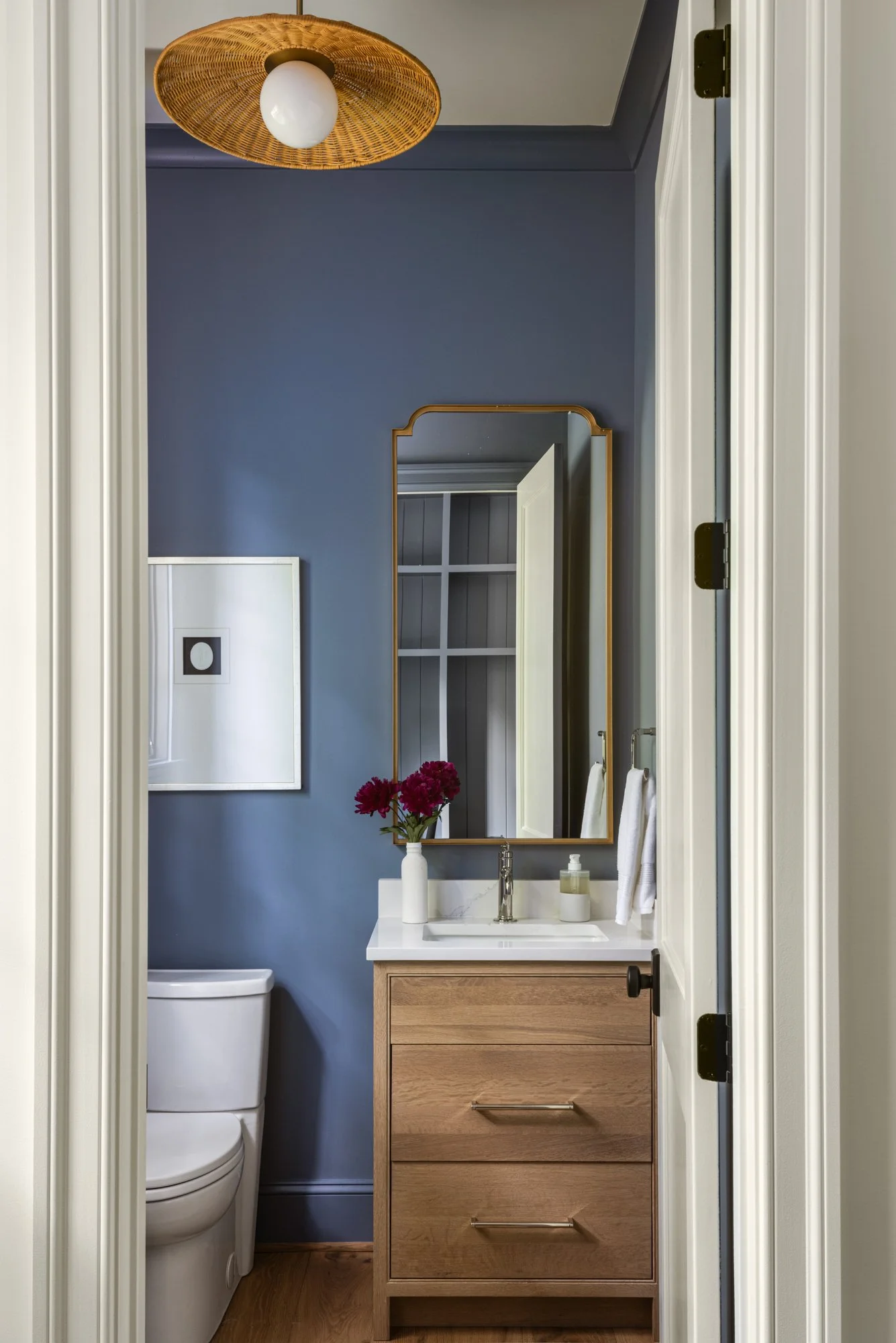 Elegant powder room interior in tailored traditional home by Wellhouse & Co.