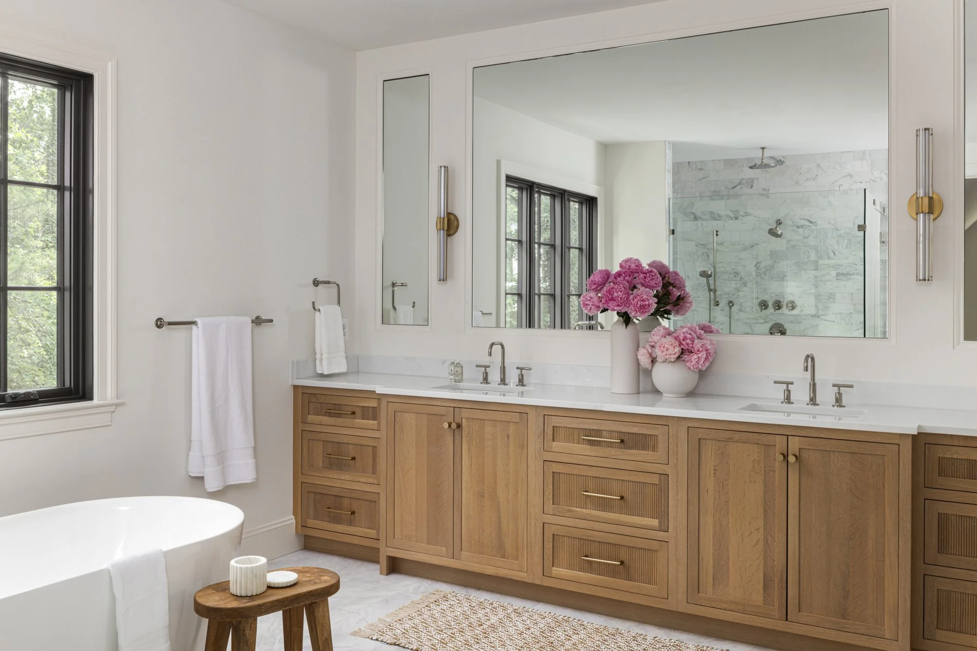 Custom double sink vanity in tailored traditional bathroom by Wellhouse & Co.