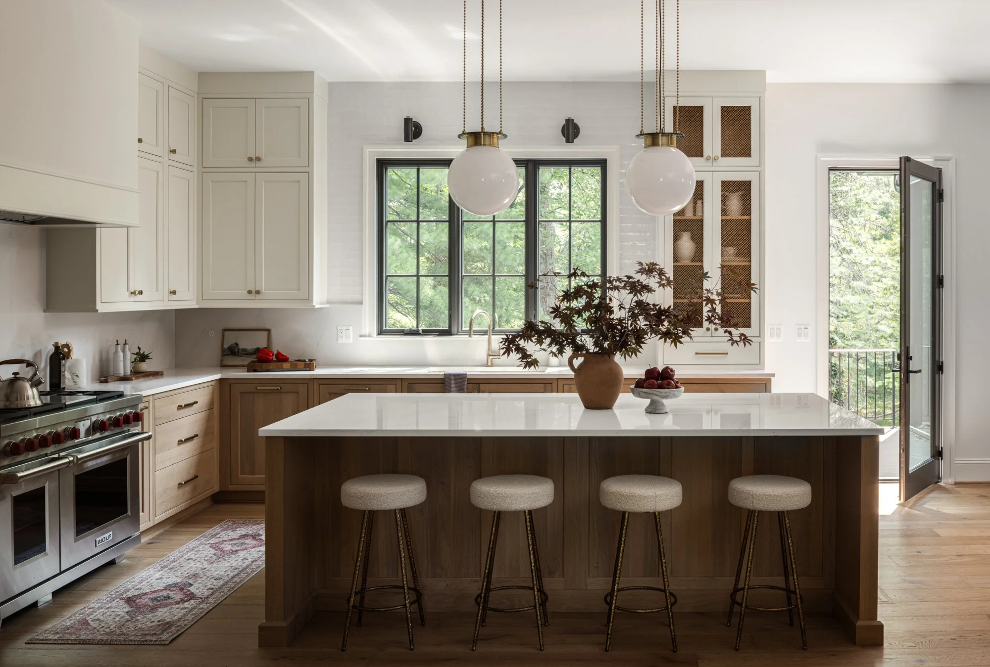 Kitchen island with seating in tailored traditional kitchen by Wellhouse & Co.