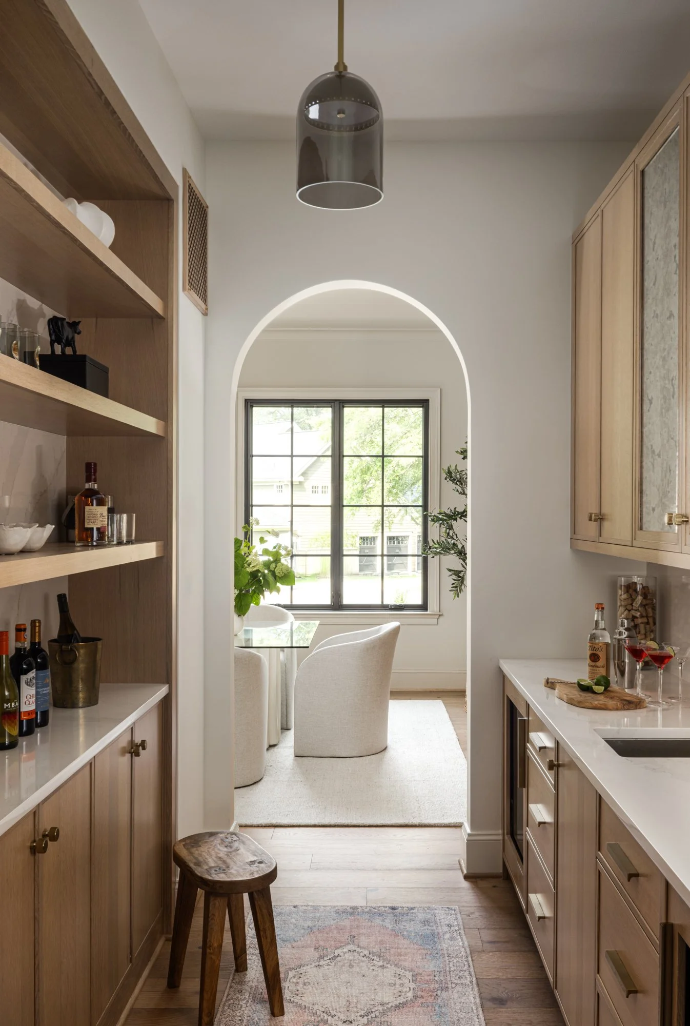 Arched doorway leading into dining room in tailored traditional home by Wellhouse & Co.