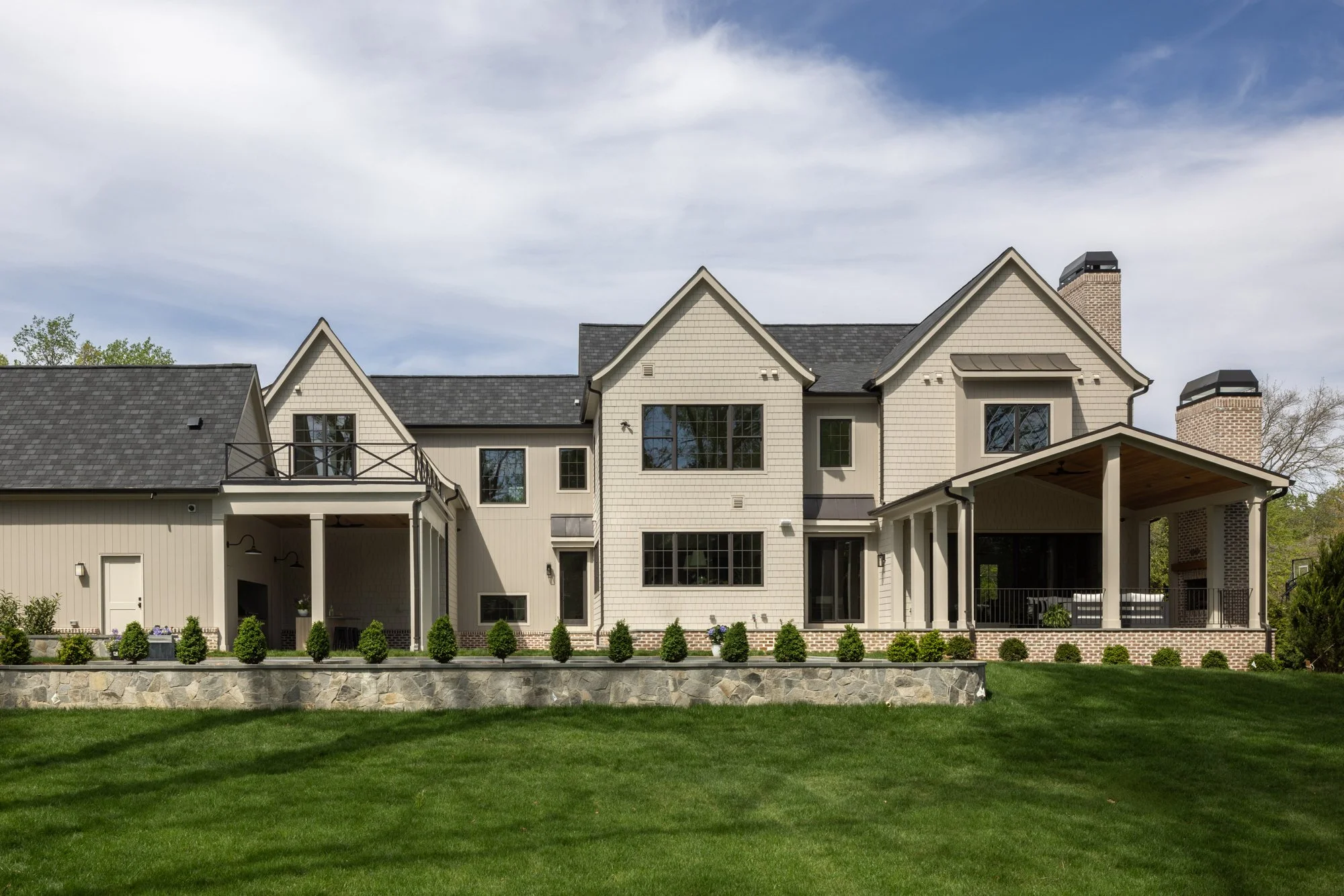 Rear elevation of modern classic estate home with outdoor living space by Wellhouse & Co.
