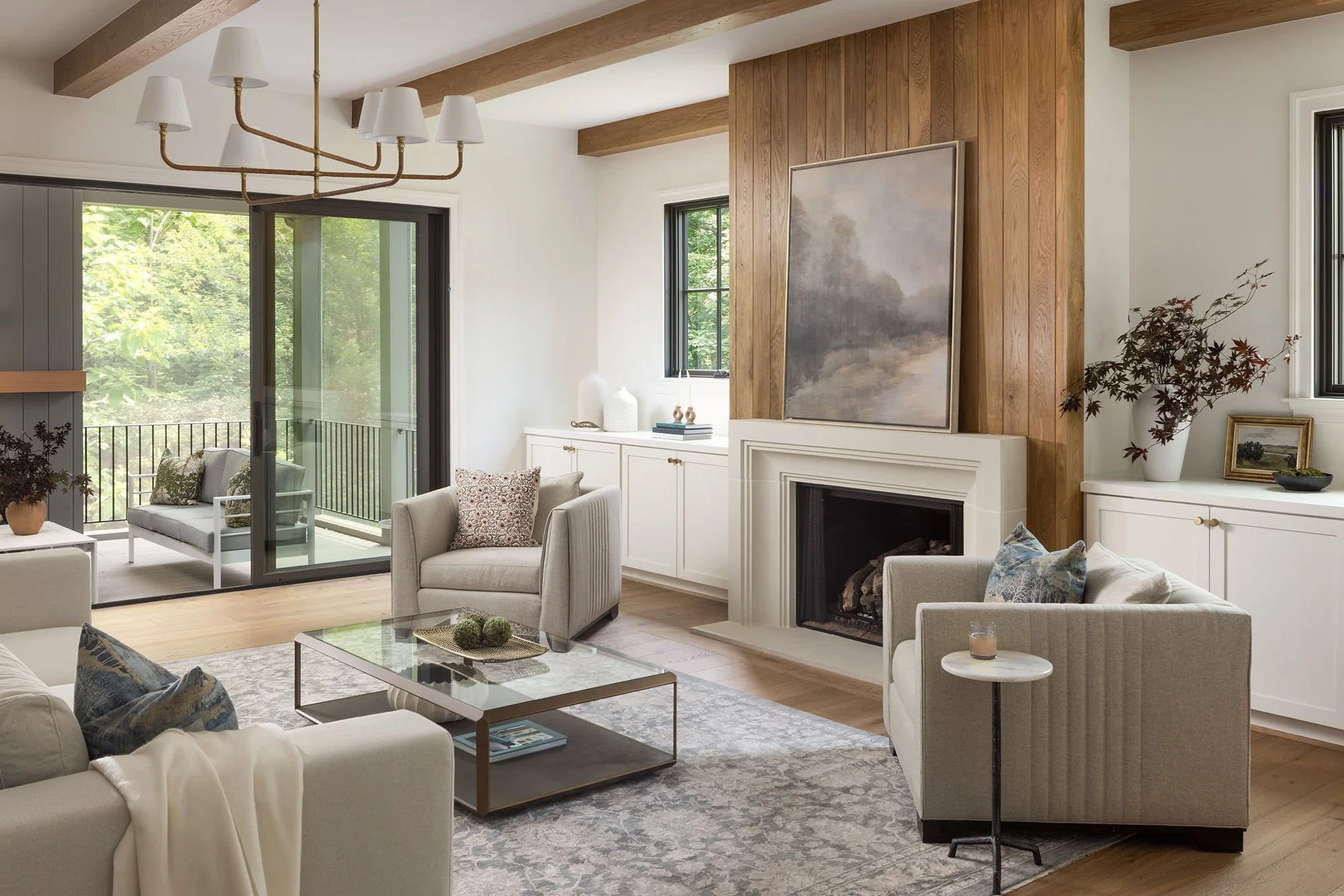 Family room with fireplace in tailored traditional home by Wellhouse & Co.