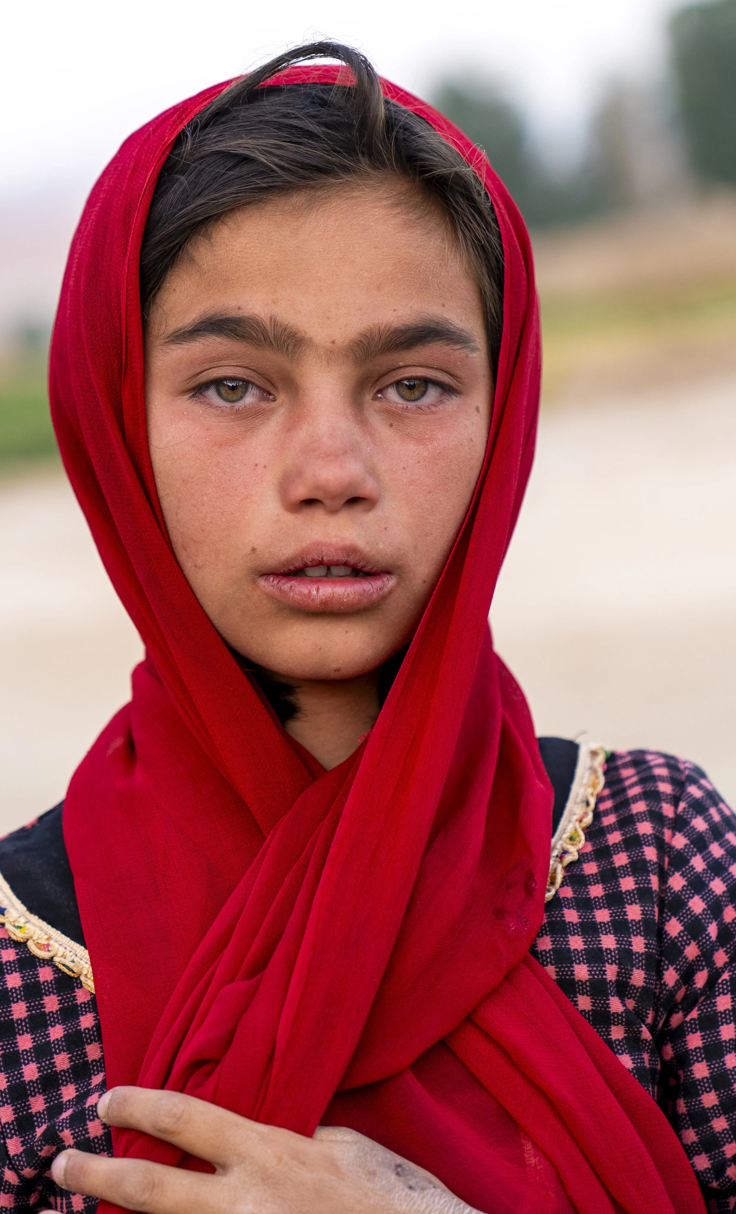 Bamiyan.
In front of the cliff, where the Buddha once stood.
She walked by quick, alert, full of life.
I asked, she stopped. Just for a second.
A brief moment, caught between stone and light.
It was Muharram.
The streets echoed with chants and devot