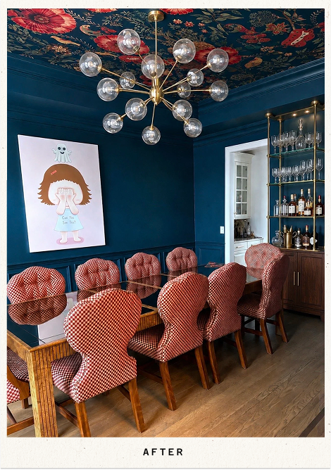 Eclectic dining room with red checkered chairs, dark blue walls, floral ceiling wallpaper, globe chandelier, artwork, and glassware cabinet
