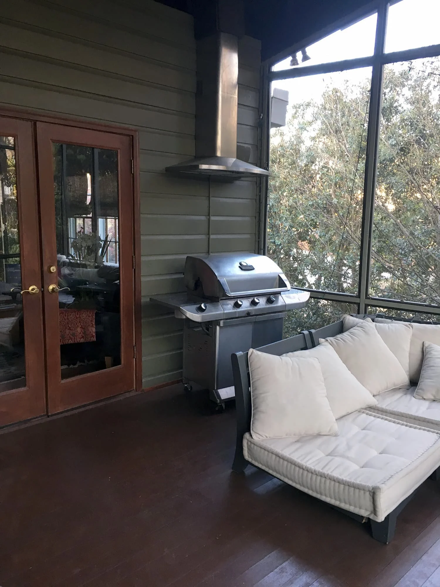 Gas grill with vent hood on screened porch