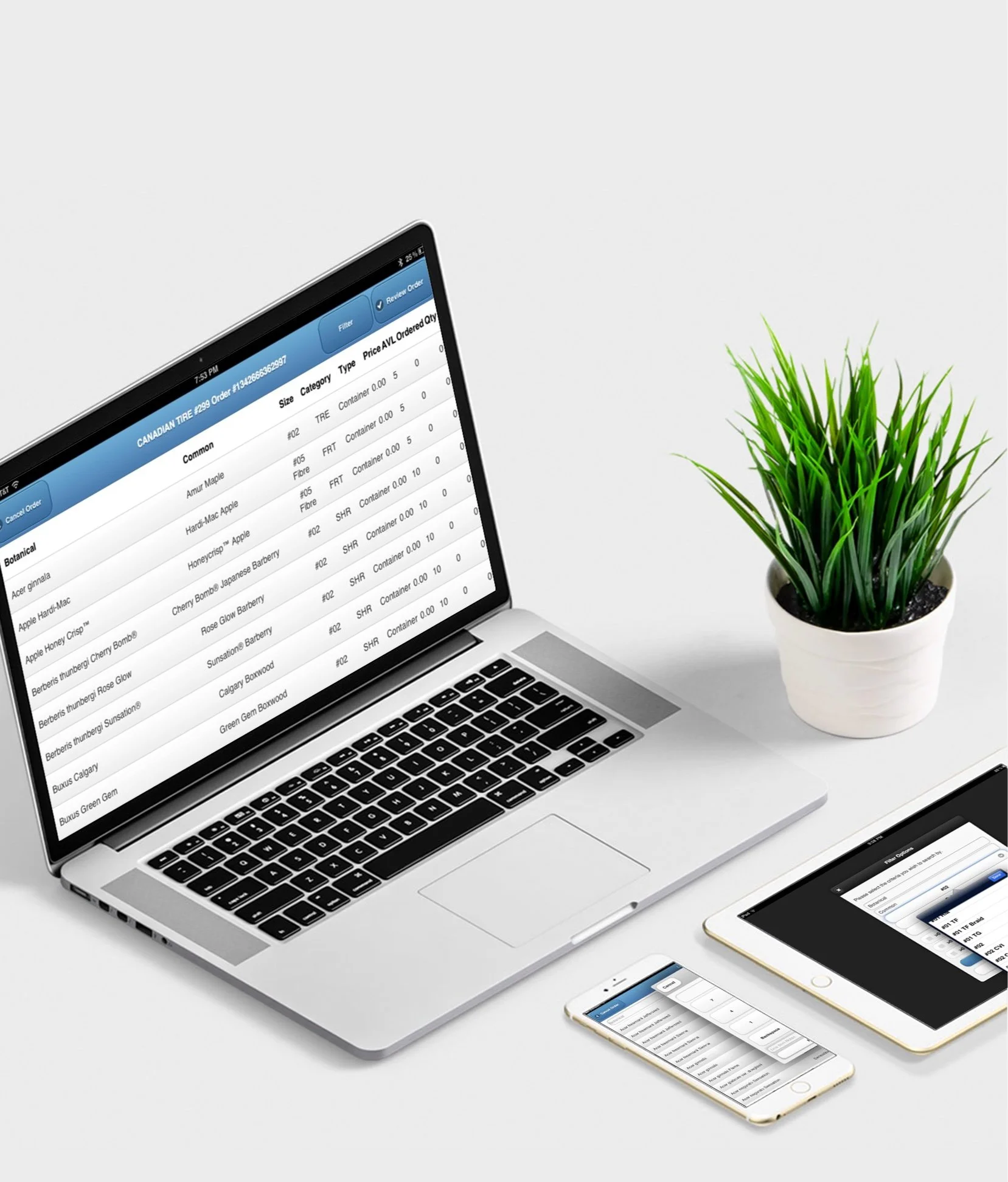 Laptop displaying the Seed Lot Management app, green plant in white pot, sitting on a white table