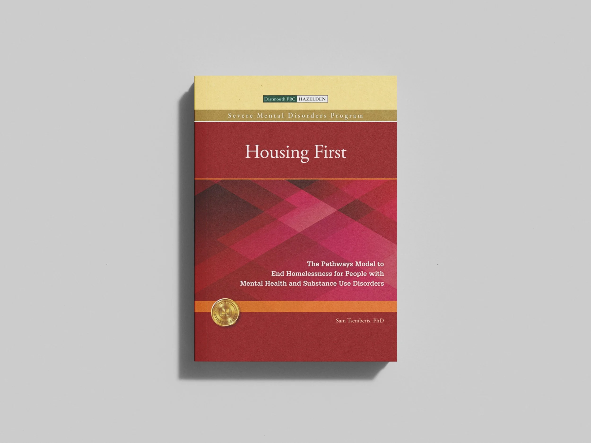 Book titled 'Housing First' with a red, pink, and orange geometric design on the cover.