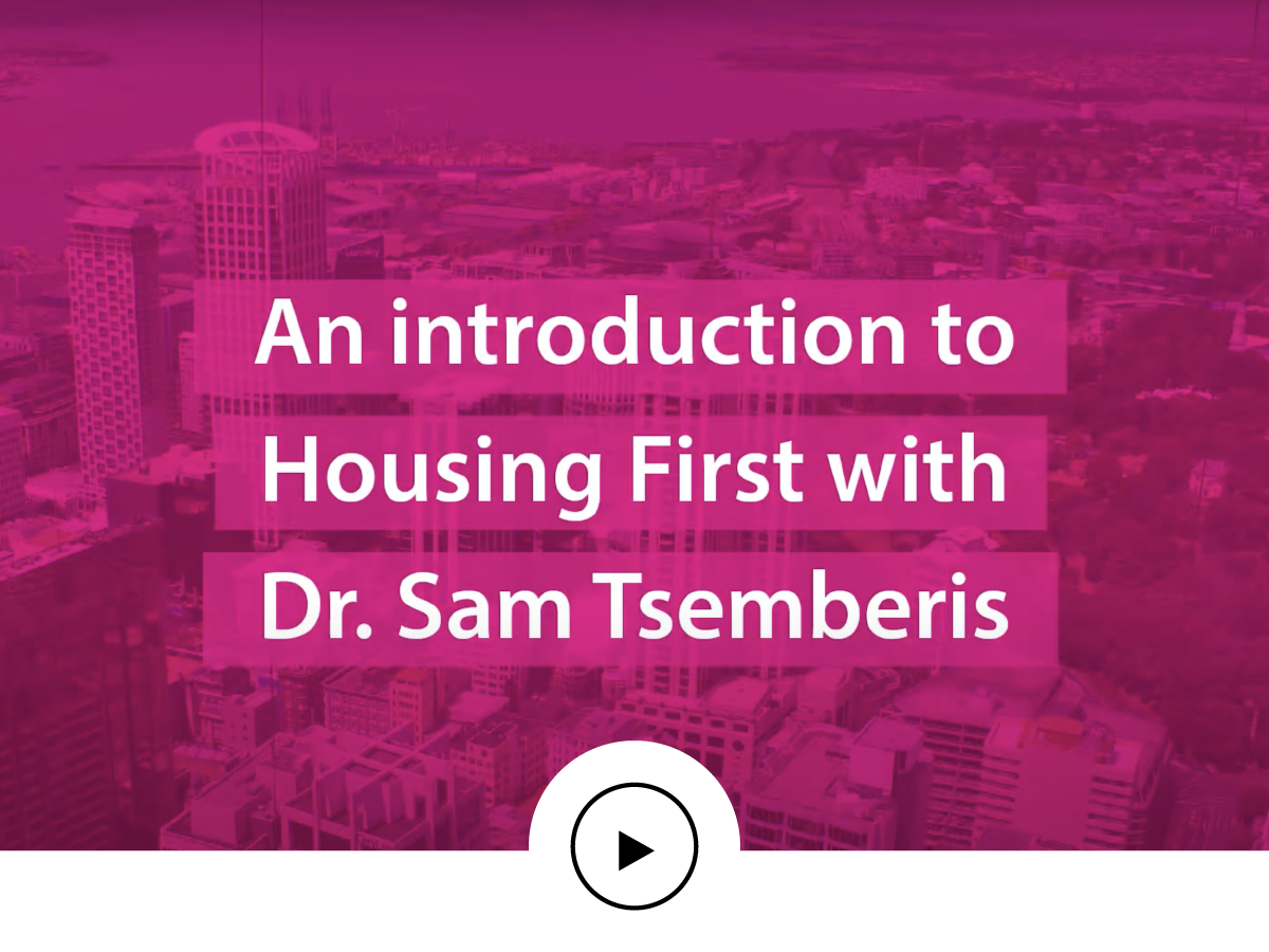 Title slide of a presentation with purple cityscape background reading 'An introduction to Housing First with Dr. Sam Tsemberis' and a play button icon below.