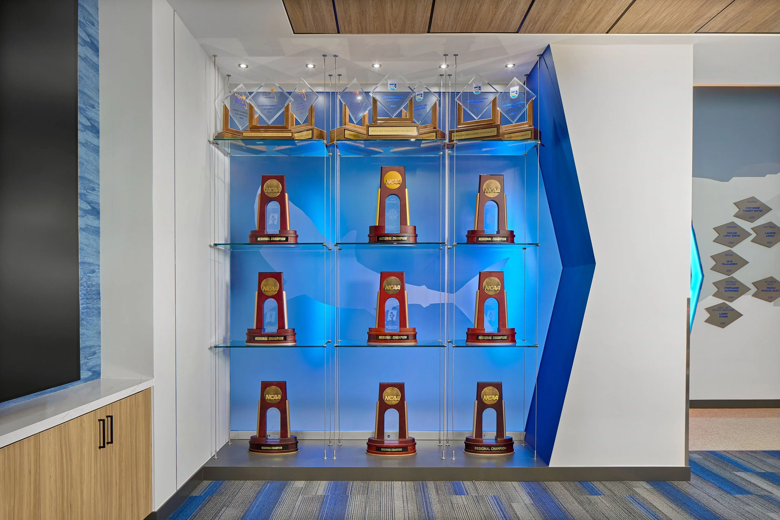 Athletic clubroom trophy case display at Rick Case Arena, Nova Southeastern University, showcasing S3 Design’s architecture and interior design for collegiate athletic facilities.