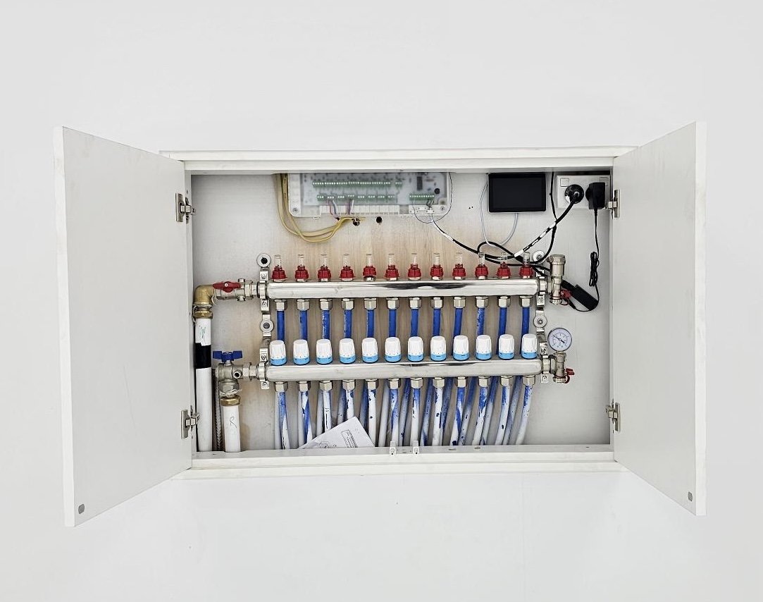 Open cabinet housing a water manifold system with multiple valves and pipes.