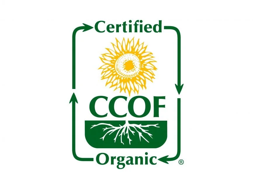 Green certified organic crop certification label with a sun, plant roots, and arrows indicating growth.